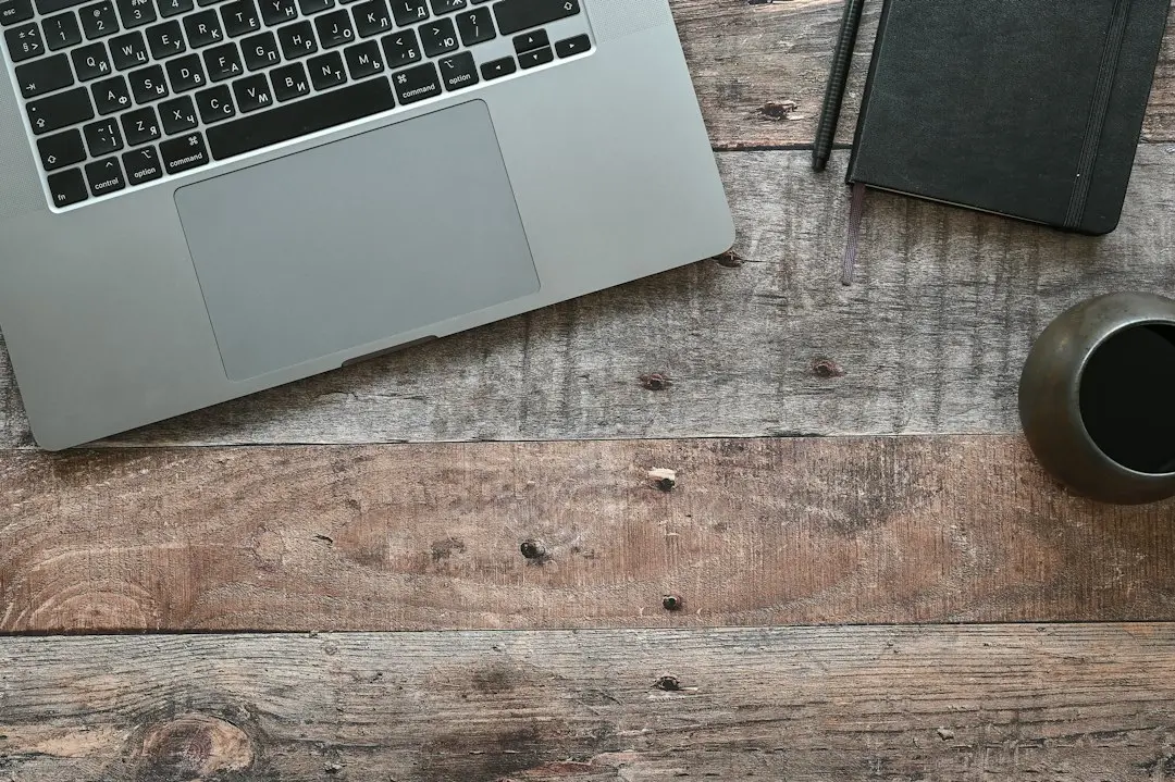 A laptop, a notebook and a coffee cup on a desk, planning a GoFluxTv IPTV reseller account